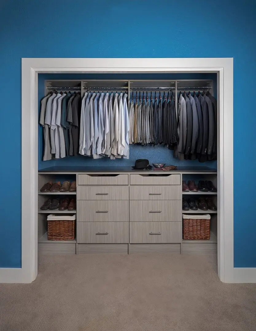 A walk in closet with a blue wall.