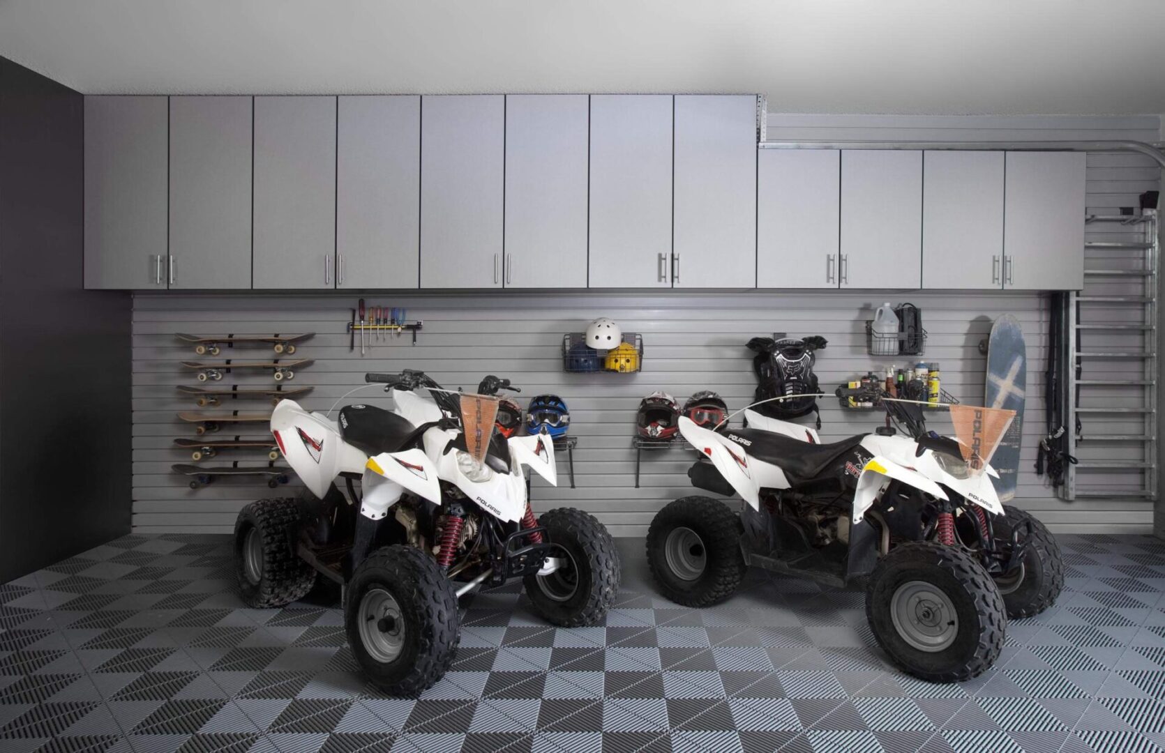 Two atvs are parked in a garage.