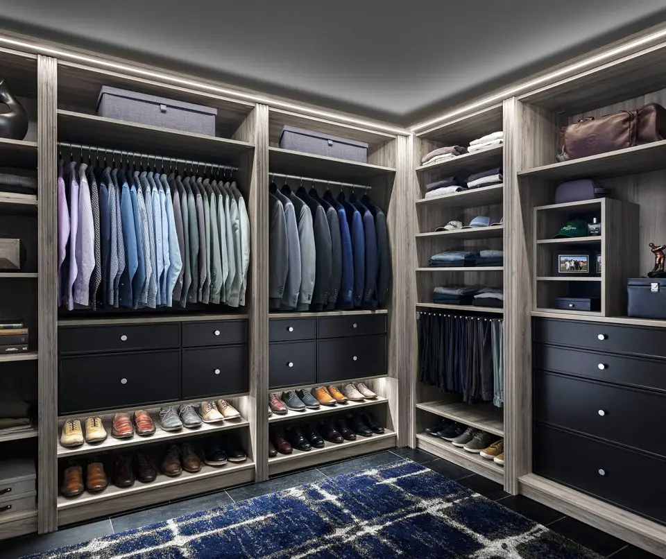 A walk in closet with a lot of clothes and shoes.